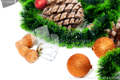 Image of Christmas tinsel, Christmas-tree balls, pine cones and champagne