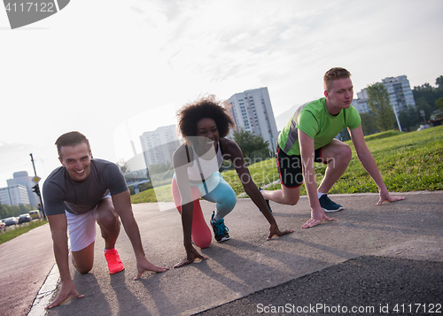 Image of multiethnic group of people on start position for jogging