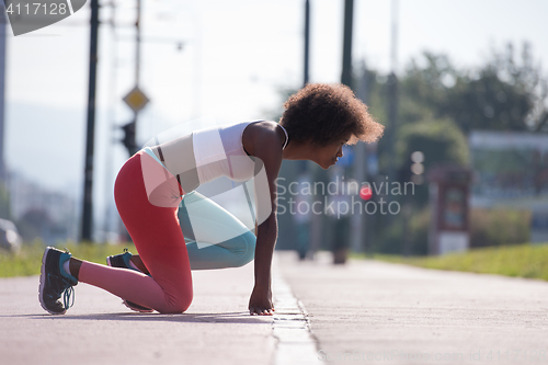 Image of Portrait of sporty young african american woman stretching outdo