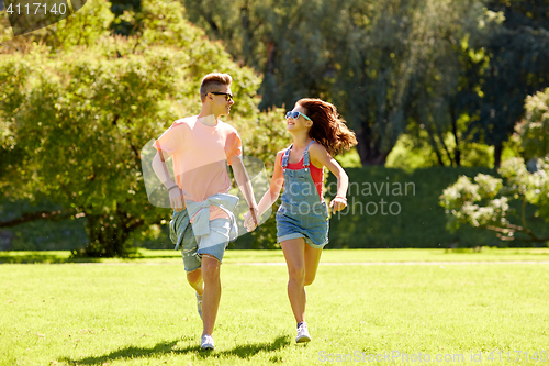 Image of happy teenage couple running at summer park