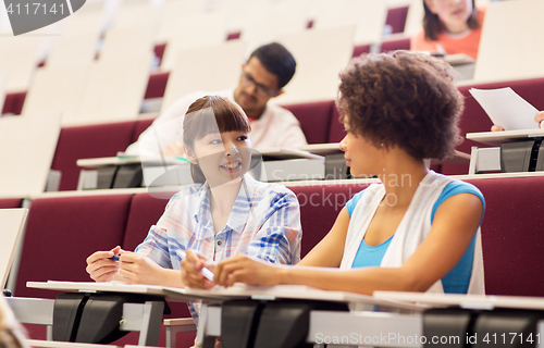 Image of group of students talking in lecture hall