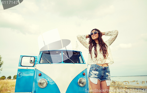 Image of smiling young hippie woman in minivan car