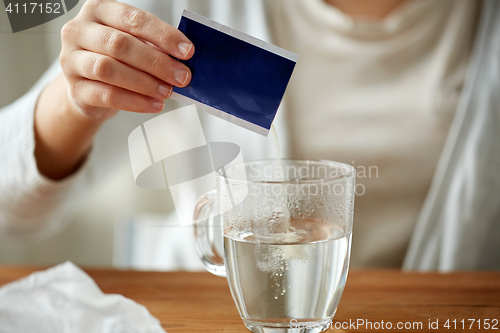 Image of woman pouring medication into cup of water