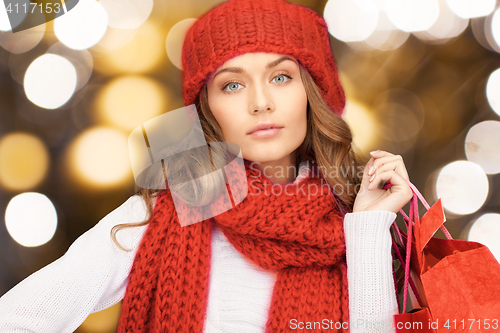 Image of woman in red hat and scarf holding shopping bags