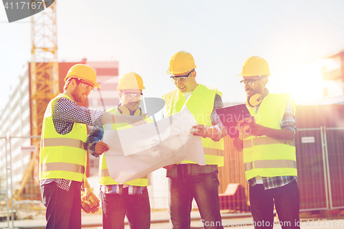 Image of group of builders with tablet pc and blueprint