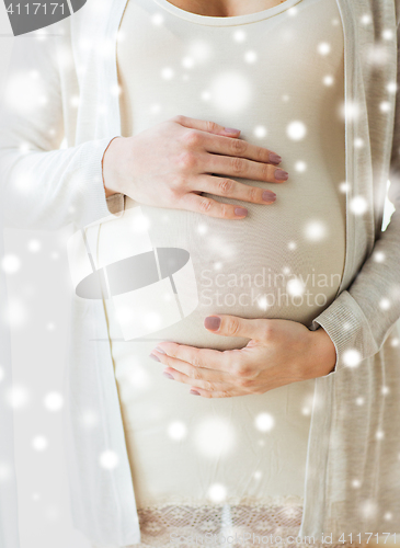 Image of close up of pregnant woman belly and hands