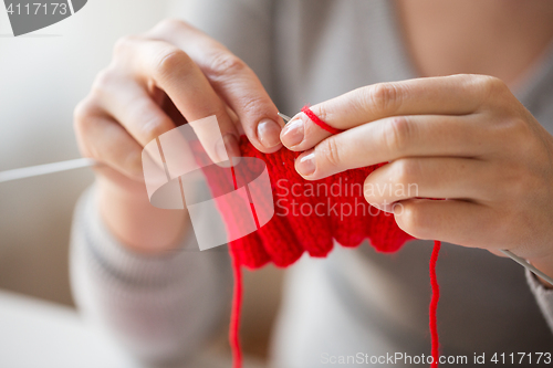 Image of close up of hands knitting with needles and yarn