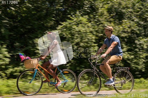 Image of Young  couple having joyful bike ride in nature