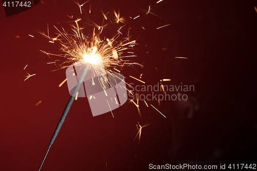 Image of Christmas sparkler on red background