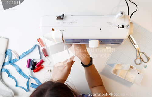 Image of Girl sets up sewing machine