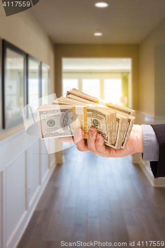 Image of Male Hand With Stack of Cash Inside Hallway of House