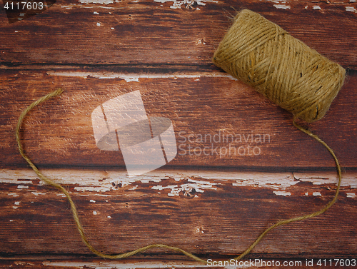 Image of Rough thread reel on wood background