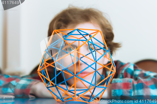 Image of Young Man Behind The Volumetric Model Of Geometric Solid