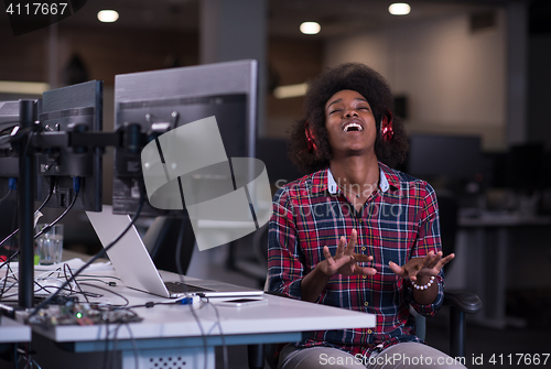 Image of woman at her workplace in startup business office listening musi