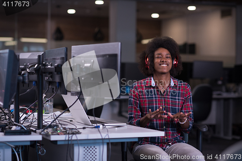 Image of woman at her workplace in startup business office listening musi