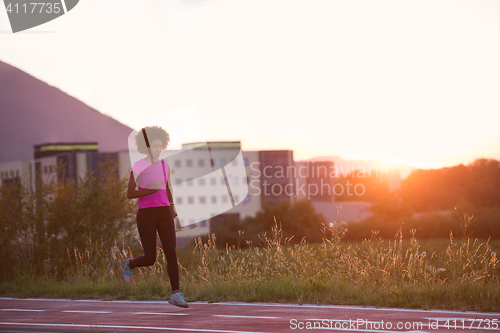 Image of a young African American woman jogging outdoors