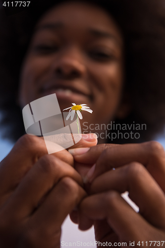 Image of portrait of African American girl with a flower in her hand