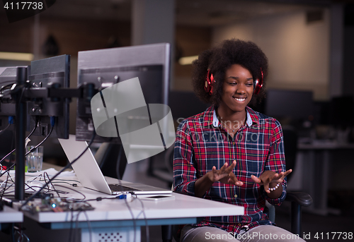 Image of woman at her workplace in startup business office listening musi