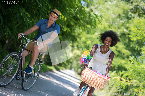 Image of Young  couple having joyful bike ride in nature