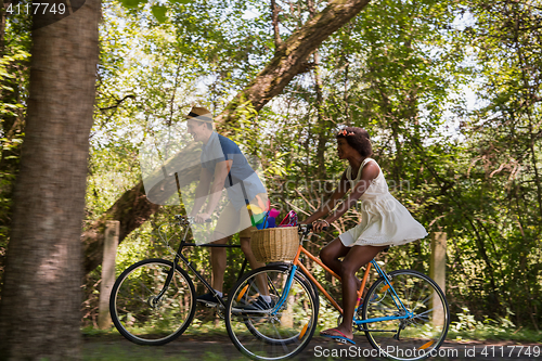 Image of Young  couple having joyful bike ride in nature