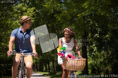 Image of Young  couple having joyful bike ride in nature