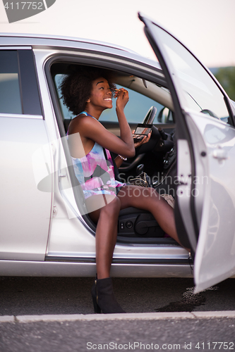 Image of a young African-American woman makeup in the car