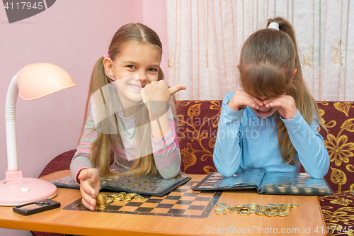 Image of Older sister hurt her younger sister and laughing at her