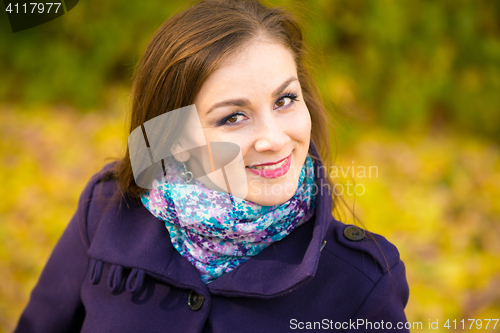 Image of Portrait of a smiling beautiful girl on the blurry background of autumn leaves