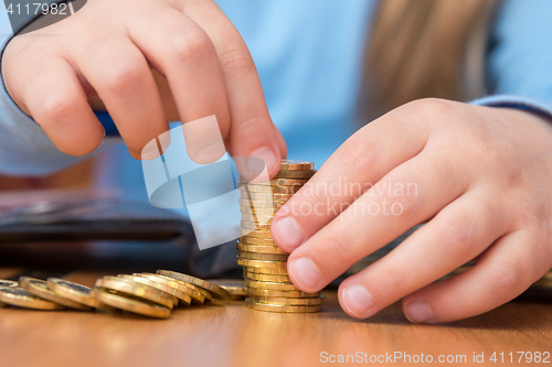 Image of Child collects a stack of golden coins, close-up