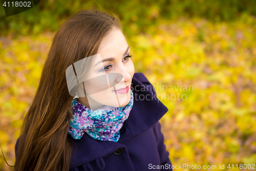 Image of Rub a beautiful girl on the blurry background of autumn leaves