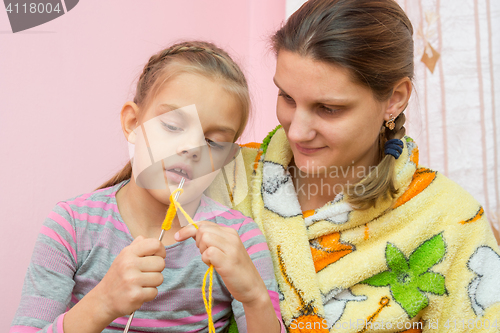 Image of Mom teaches daughter to knit seven years
