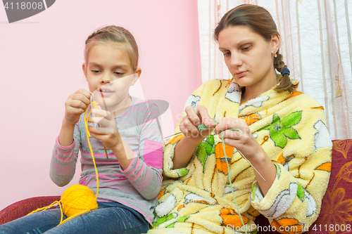 Image of Mom and daughter seven-year-knit on the needles sitting on the couch