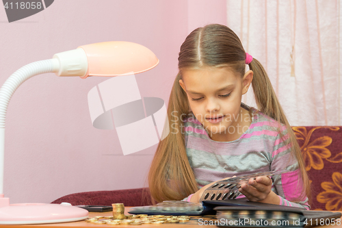 Image of Carried away by the girl leafing through the album for collecting coins