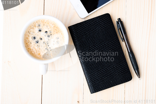 Image of Smartphone with notebook and cup of strong coffee