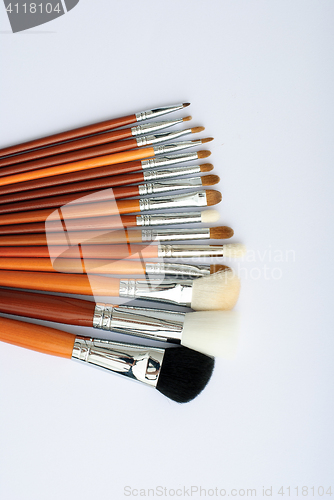 Image of makeup brush and cosmetics, on a white background