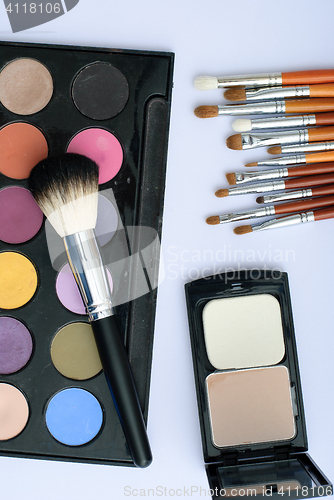 Image of makeup brush and cosmetics, on a white background