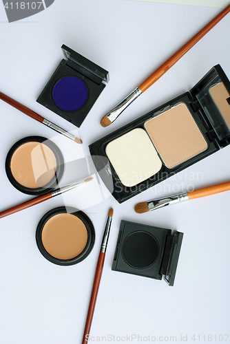 Image of makeup brush and cosmetics, on a white background