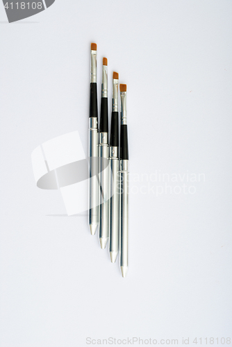 Image of makeup brush and cosmetics, on a white background