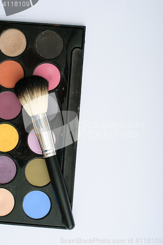 Image of makeup brush and cosmetics, on a white background