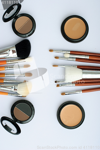 Image of makeup brush and cosmetics, on a white background