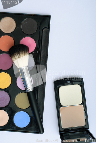 Image of makeup brush and cosmetics, on a white background