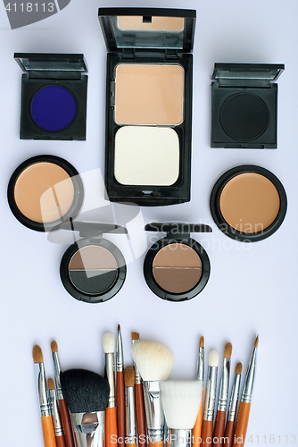 Image of makeup brush and cosmetics, on a white background