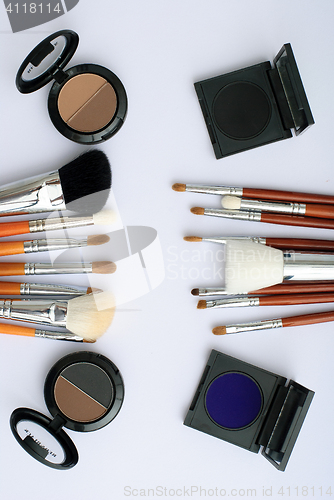 Image of makeup brush and cosmetics, on a white background