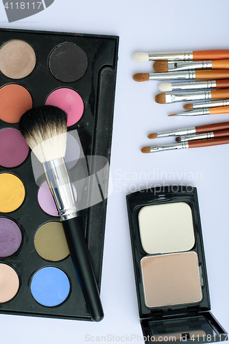 Image of makeup brush and cosmetics, on a white background