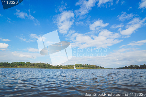 Image of River landscape with a sailboat in the water