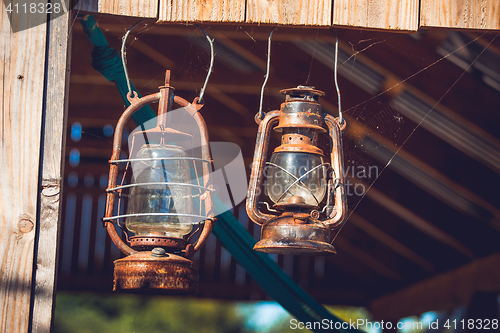 Image of Vintage lanterns hanging in an old barn