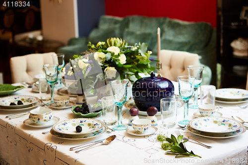 Image of Beautifully decorated table set with flowers, candles, plates and serviettes for wedding or another event in the restaurant.