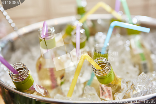 Image of bottles with tasty drink in ice. Shallow dof