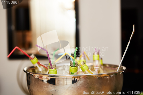 Image of bottles with tasty drink in ice. Shallow dof