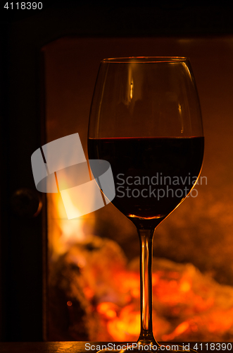 Image of Glowing fire with a glass of red wine